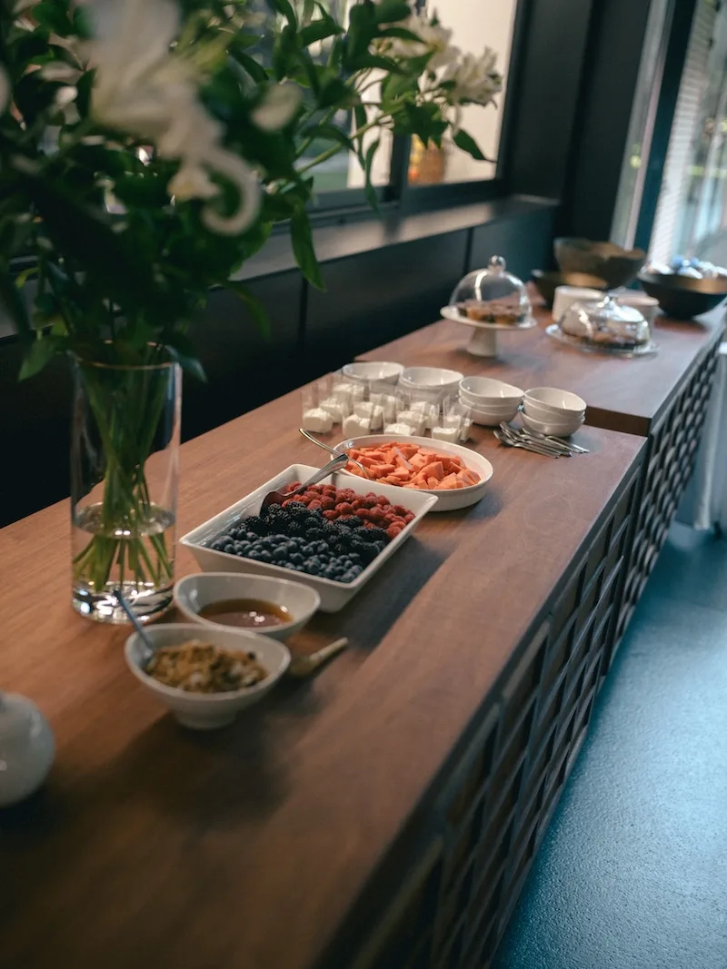 Barra de desayuno con fruta fresca, café y bocadillos ligeros preparada para la mañana de una boda