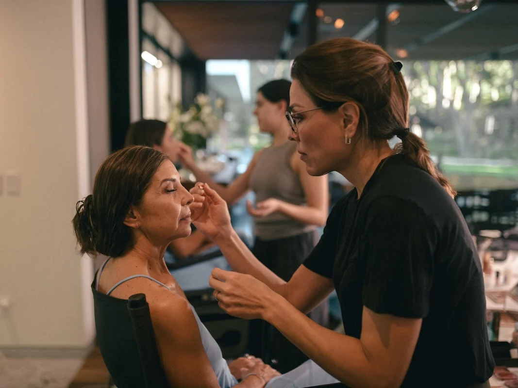 Ana Paula Celis doing a client's makeup on a wedding morning